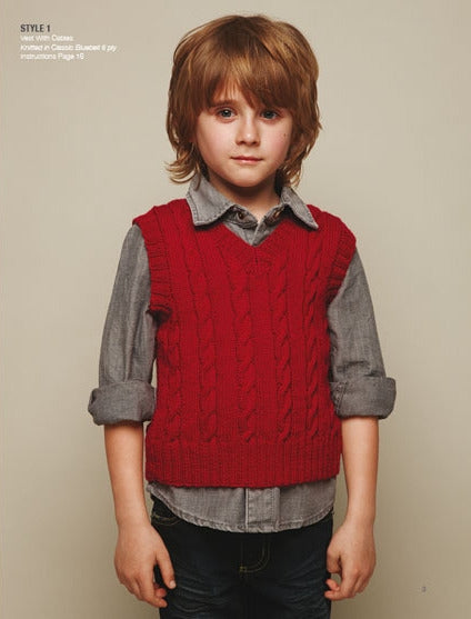 Young child with brown hair in a casual pose, wearing a red knit vest over a gray button-up shirt, expressing a calm and neutral demeanor.