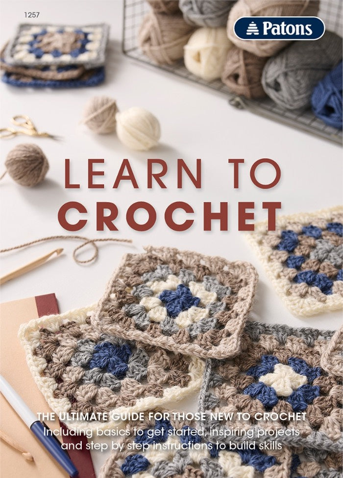 Crochet guide cover with colorful granny squares, yarn balls, and crochet tools on a table. The text reads 'Learn to Crochet.' Warm, inviting tone.