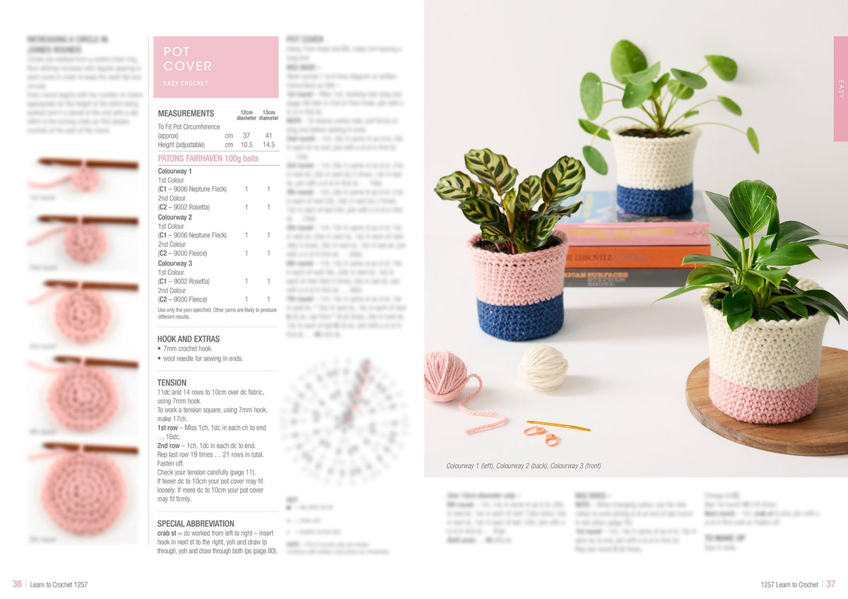 Crochet pot covers in pink and blue on potted plants beside crochet materials. Instruction text on left. Bright, inviting craft project setup.