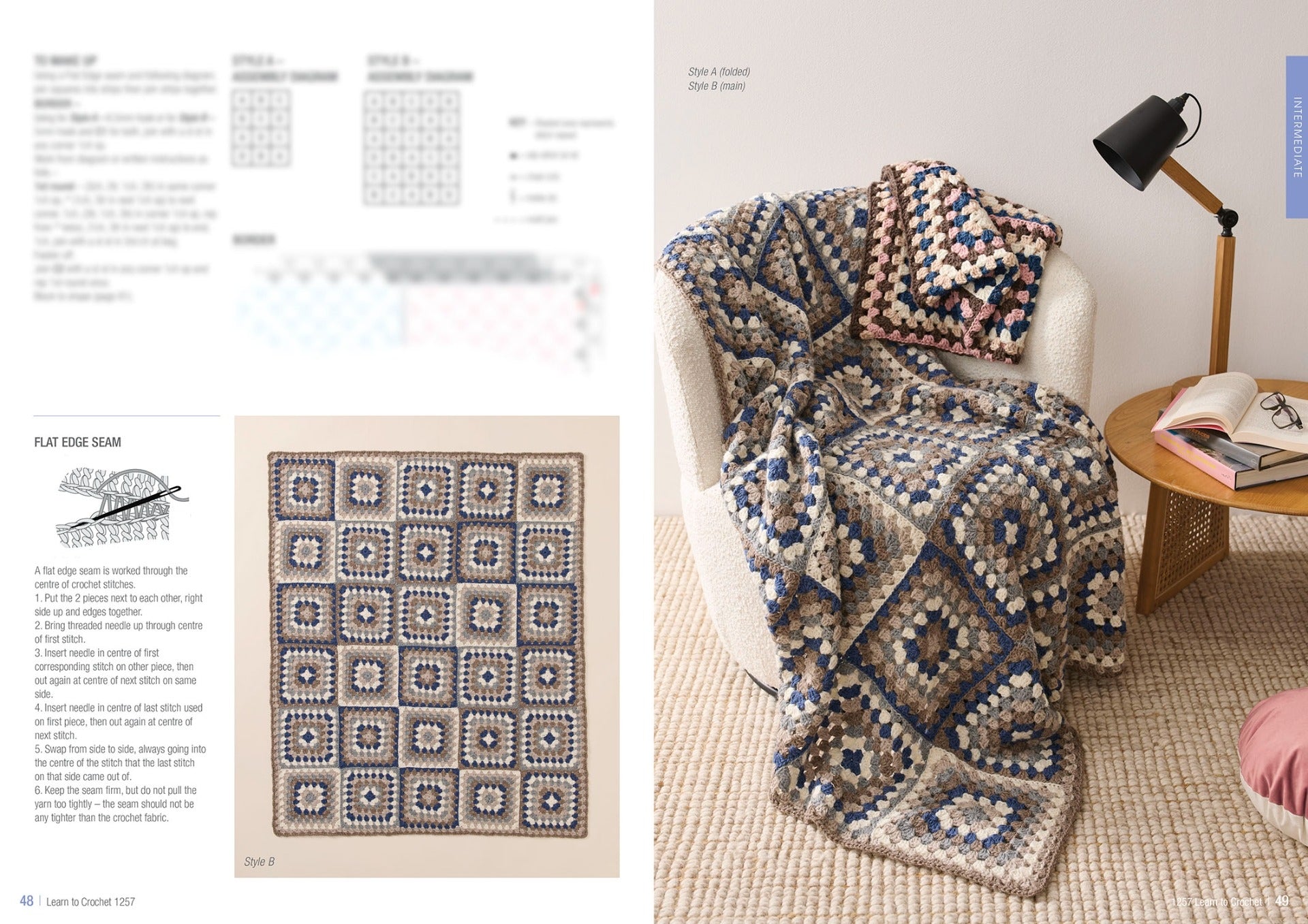 Cozy corner with a beige armchair draped in a blue and cream crocheted blanket. Matching pillow and open book on wooden table under a black lamp.