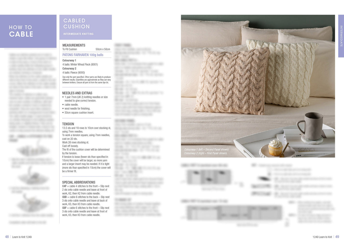 Cozy knitted cushions with cable patterns on a beige sofa. Nearby, a tray holds a grey mug and cupcake. Instructions for intermediate knitting on the left.