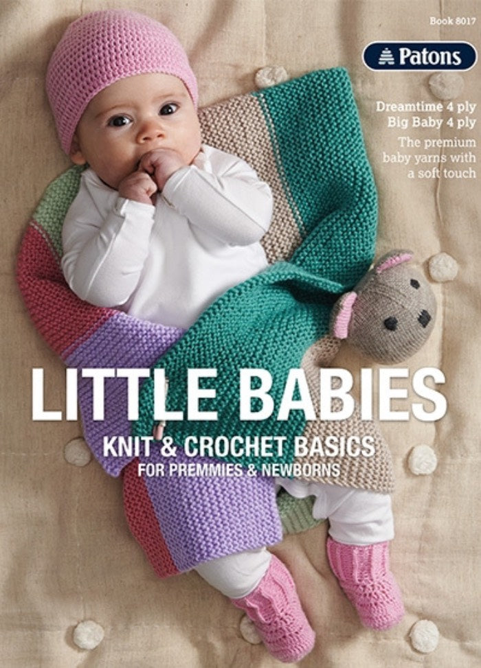 A baby wearing a pink hat and booties is wrapped in a colorful knitted blanket on "Little Babies: Knit & Crochet Basics" cover. The mood is cozy and tender.