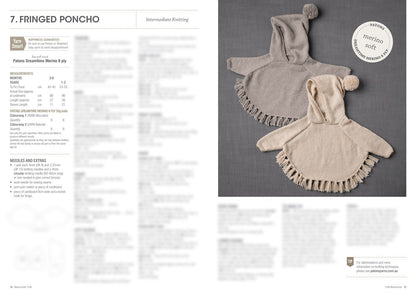 Two knitted ponchos with hoods and fringes lay side by side on a gray surface. One is gray, and the other beige. The setting conveys warmth and coziness.