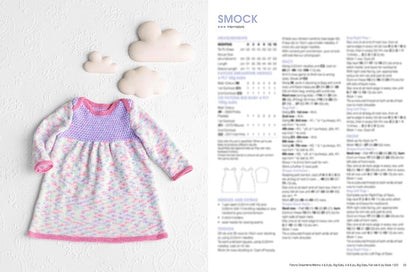A pastel-colored knitted baby smock with pink trim lies on a textured white background with cloud decorations. Pattern instructions are visible on the right.