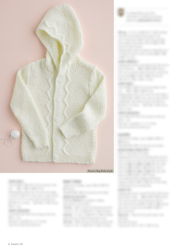 Cream-colored knitted baby cardigan with hood, zigzag pattern on the button strip, and white buttons. Yarn ball on the side. Warm, cozy feel.