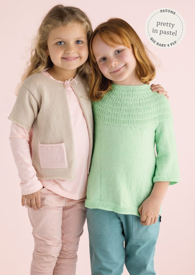 Two smiling girls wearing pastel knitwear. One in pink and beige, the other in mint green. The background is soft pink. Text: "Pretty in Pastel."