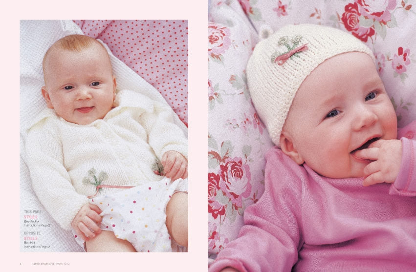 Two babies lie on floral-patterned blankets. The left baby wears a white knit cardigan and polka-dot shorts, smiling. The right baby in pink, with a knitted hat, playfully sucks fingers. Both appear joyful and content.