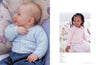 Baby in a blue knit sweater smiles on floral cushions; a young girl in a pink sweater and tulle skirt looks serious on floral pillows. Cozy and tender mood.