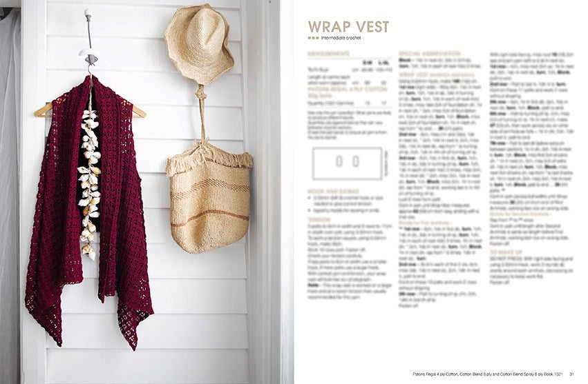 A crocheted maroon wrap vest hangs on a wooden hanger beside a straw hat and bag on a white paneled wall. Text on the right describes the wrap vest pattern.