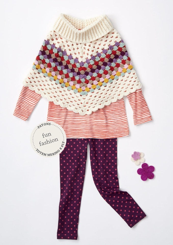 Children's outfit with a colourful crochet poncho over a red striped top, paired with purple polka dot leggings. Two felt flowers add a playful touch.