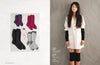 Half of the image shows five pairs of socks in various colors and patterns. The other half features a woman in a white shirt dress with black arm warmers and leg warmers, standing against a wooden backdrop. The mood is stylish and cozy.