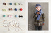 Colourful yarn balls are arranged on the left, spelling "Spilly" with brown yarn. On the right, a child wears a knitted hat, scarf, and gloves, looking cozy.