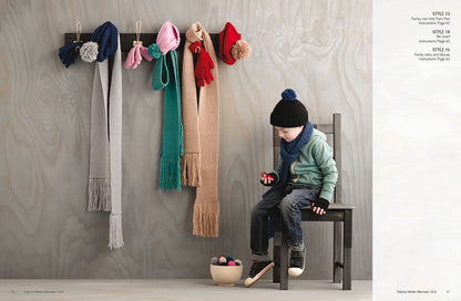A child in winter clothes sits on a chair, holding a red toy. Colorful scarves and hats hang on the wall. The scene feels cozy and playful.