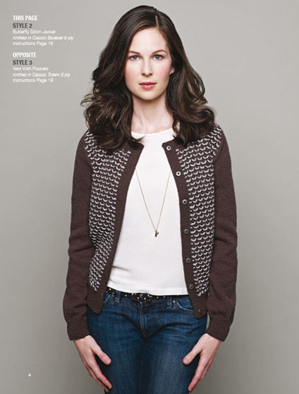 Woman with long brown hair wears a patterned brown cardigan over a white shirt and jeans, standing confidently against a gray background.