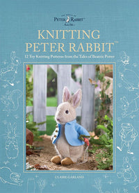 Cover of “Knitting Peter Rabbit” by Claire Garland, featuring a knitted Peter Rabbit toy in a blue jacket standing outdoors near greenery and a wooden fence. The subtitle reads “12 Toy Knitting Patterns from the Tales of Beatrix Potter,” with a blue background adorned with white illustrations from Beatrix Potter’s stories.