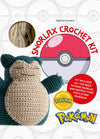 Cover of the "Snorlax Crochet Kit" by Sabrina Somers, featuring a crocheted Snorlax plush toy, a Poké Ball graphic, and text stating the kit includes materials to make Snorlax and instructions for five other Pokémon. Official Pokémon licensed product seal and logo are also visible.
