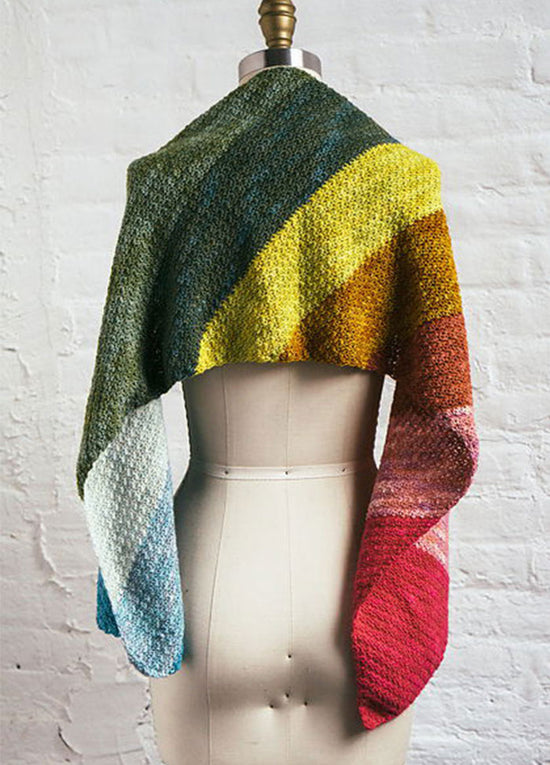Rainbow Showers Scarf on mannequin, hand-knit with a soft gradient of green, yellow, orange, red, pink, and blue.