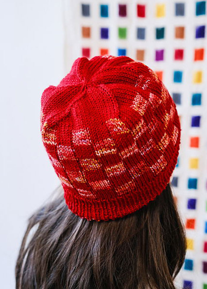 Back view of a Red Planet Hat with mosaic pattern, set against a colourful grid wall.