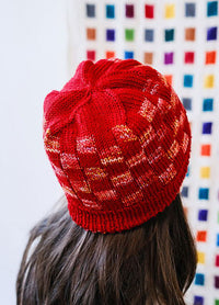 Back view of a Red Planet Hat with mosaic pattern, set against a colourful grid wall.