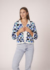 Romantic lace cardigan in pastel tones, styled over a dress for a garden-ready outfit.
