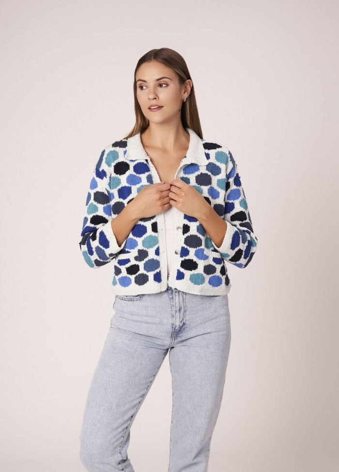 Romantic lace cardigan in pastel tones, styled over a dress for a garden-ready outfit.