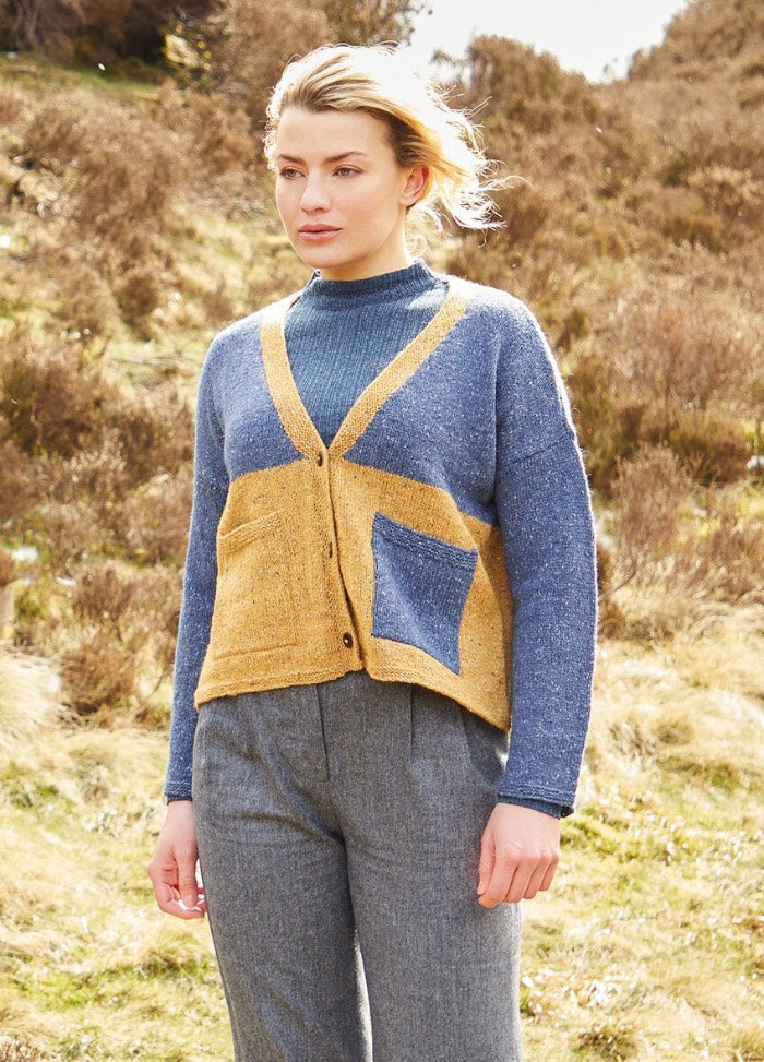 A boxy, cropped cardigan in Felted Tweed with a bold half-and-half colour block and a contrast patch pocket on the left front; designed for easy layering.