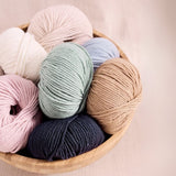 A basket with 7 balls of coloured yarns. Rowan-Mode-Merino-Soft