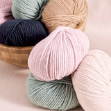 Rowan-Mode-Merino-Soft. A bunch of yarns of different colours including pink, sage, navy, sand.