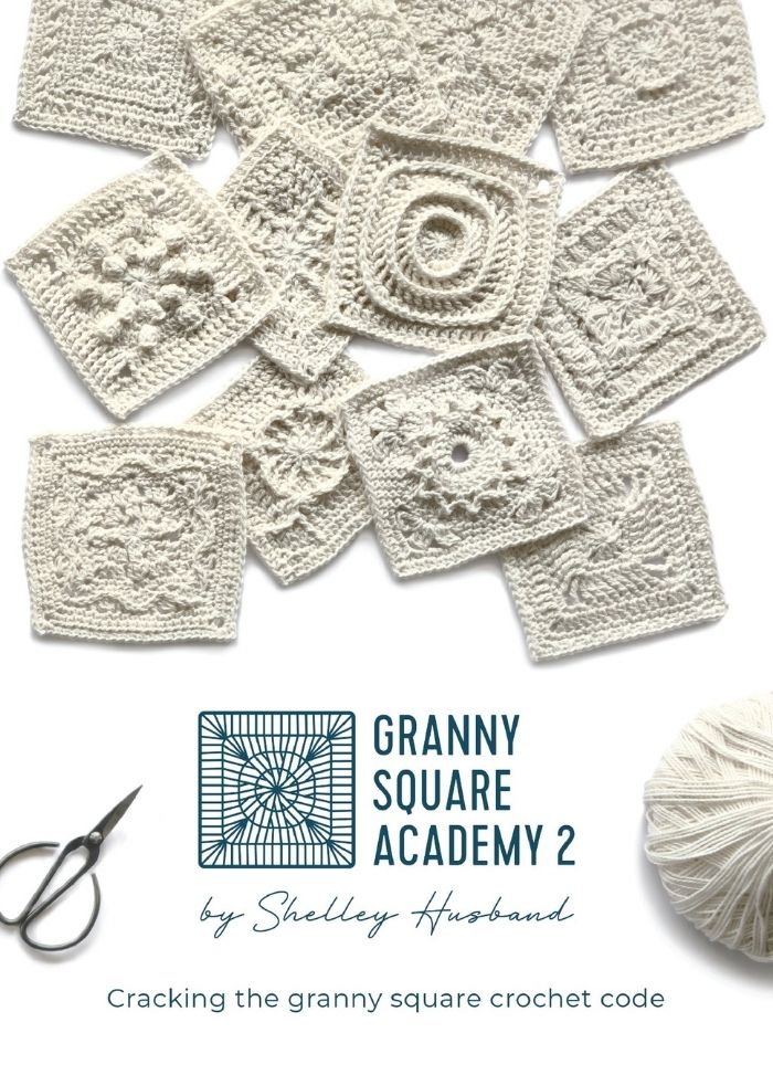 A collage of intricate white crocheted granny squares is displayed above text reading "Granny Square Academy 2 by Shelley Husband." A yarn ball and scissors are seen below, suggesting a crafting theme.