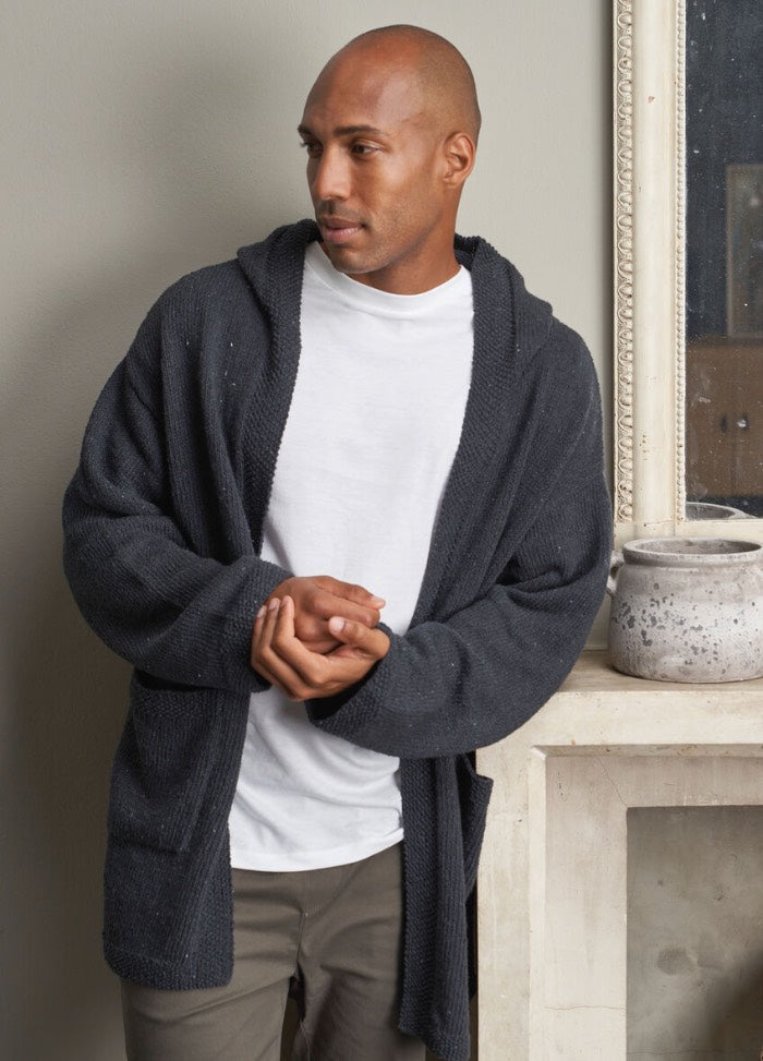 A man wearing a white t-shirt under a soft, textured gray cardigan with a relaxed fit and open front.