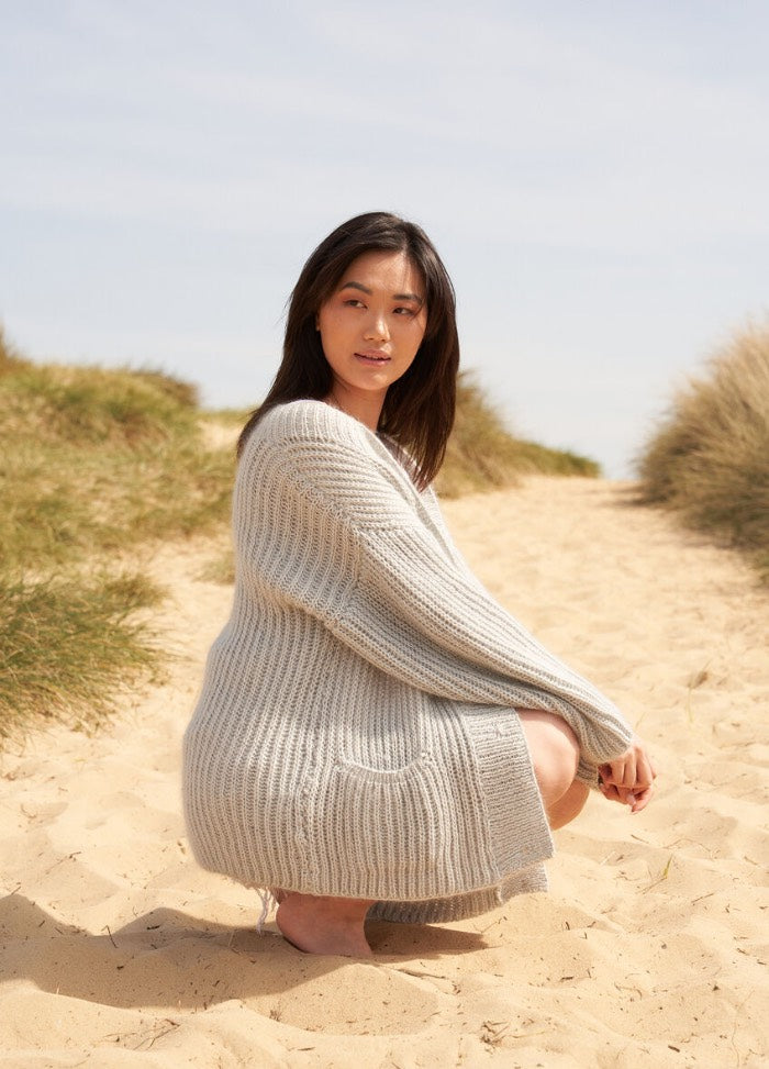 Smirk knit pattern, a playful pastel pink top with a cropped silhouette and textured stitchwork.