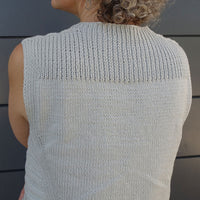 Sleeveless Summer Esio Top in a soft neutral tone, hand-knitted with lightweight yarn. Features ribbed trim at neckline and armholes, perfect for warm-weather layering or standalone wear.