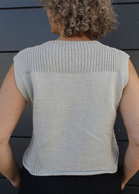 Lightweight knitted Summer Esio Top in a sleeveless design, featuring ribbed edges and a clean silhouette. Ideal for warm-weather outfits, styled with dark trousers for a modern casual look.