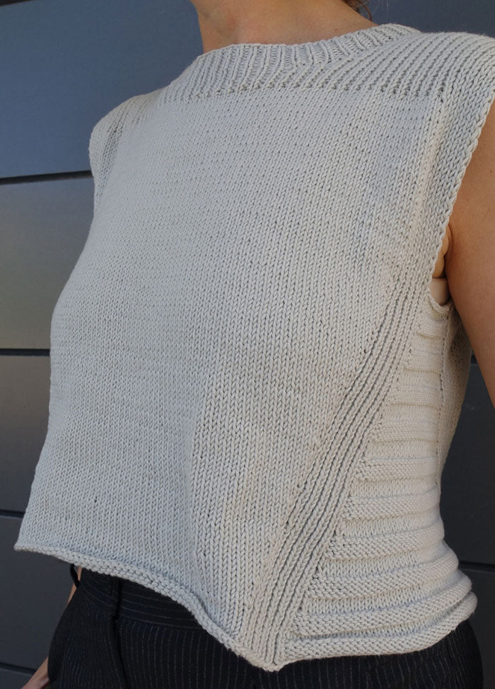 Hand-knitted Summer Esio Top in a sleeveless, airy design with ribbed neckline and armholes. Crafted in a light neutral shade, perfect for casual summer styling.