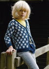 Child in blue Sundance Cardigan with white stars, yellow shirt, and light pants, by fence.