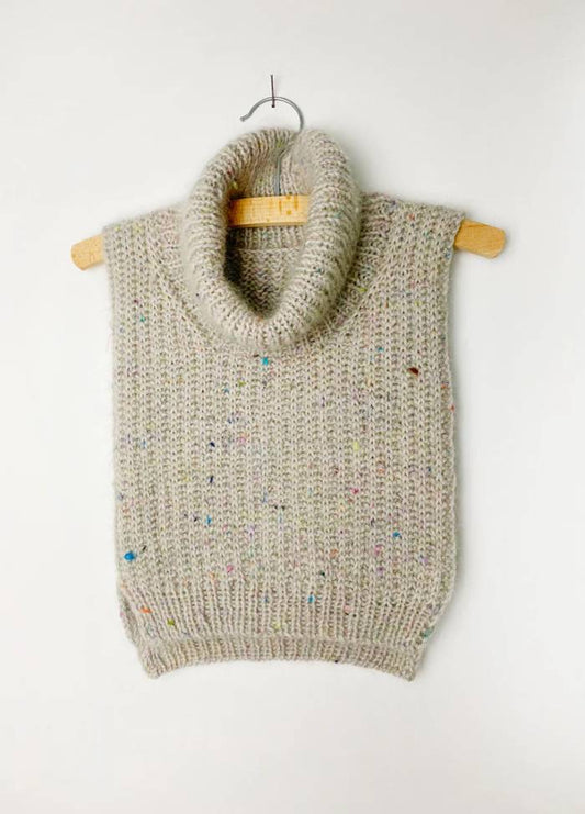 Grey knitted neckwarmer with a turtleneck on a wooden hanger, featuring multicoloured speckles, against a plain white background. Cozy and neutral tone.