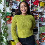 Smiling women featuring the green vivid colour she has in her duna sweater