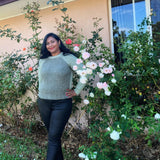 women wearing the duna sweater in a garden